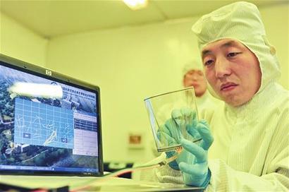 研究人员在展示单层石墨烯产品的超强透光性和柔性。