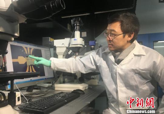 南京大学教授缪峰向记者介绍这种新结构电子元件的抗热原理。　申冉 摄