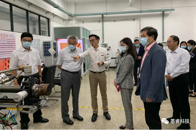 全国政协副主席、九三学社中央常务副主席邵鸿听取墨睿科技董事长蔡金明介绍石墨烯导热膜产品