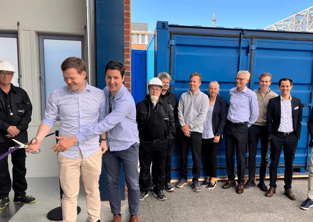 Einar Eilertsen cuts the ribbon in front of other guests