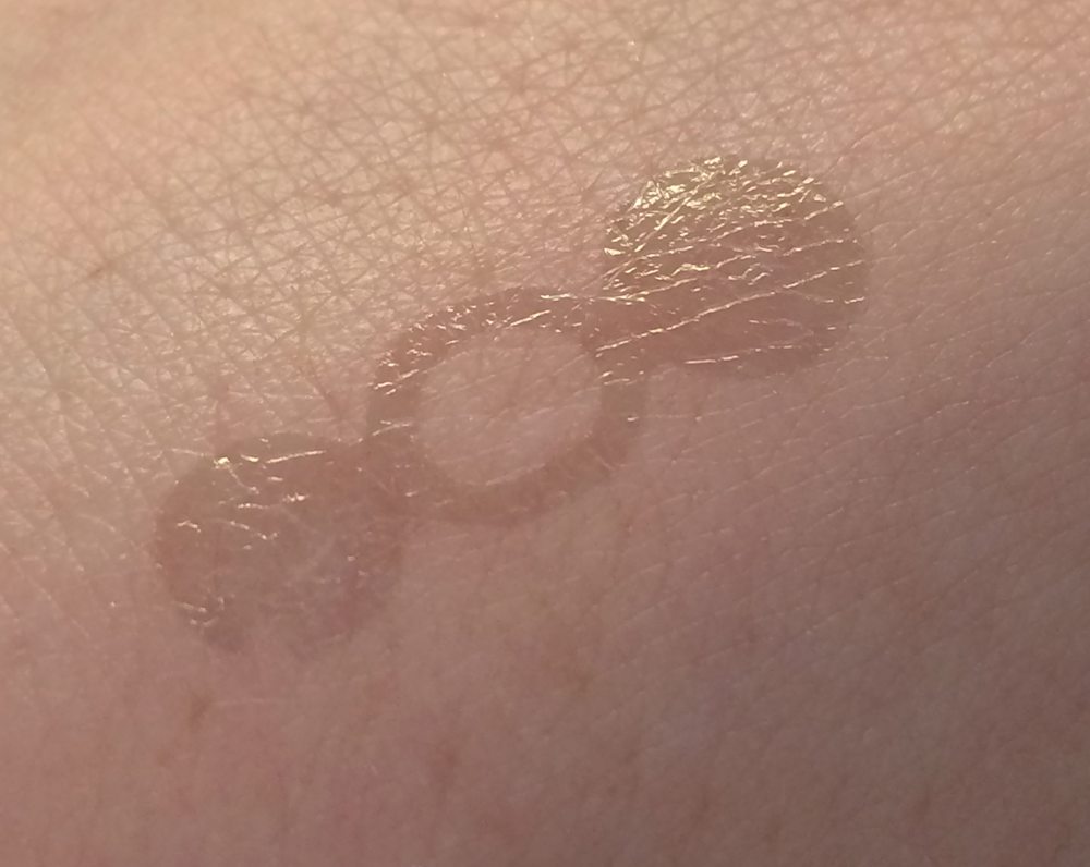 A close-up photo shows an area of skin with a nearly invisible clear shape adhering to the skin. 