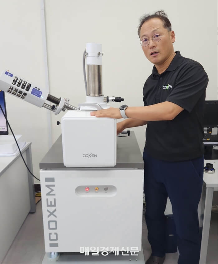 Cosem代表李俊熙(音)正在说明可以将多种大小的样本扩大到50万倍的扫描电子显微镜。 《李汉娜记者》