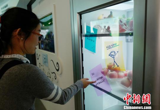 近日，记者跟随“调结构转方式·北京调研行”采访团，走访了中关村、北京经济技术开发区等地。图为京东方公司展厅内，民众体验最新的透明显示技术，在电冰箱上可以“写”便条。　侯宇 摄