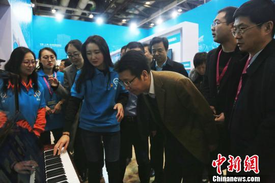 共青团中央书记处常务书记、全国青联主席贺军科在2017国际创新创业博览会观看智慧钢琴演示。主办方供图