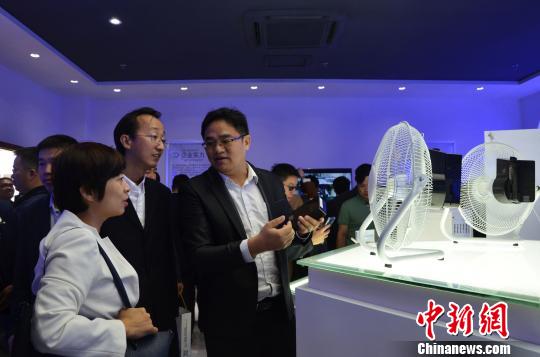 图为参观者在观看用石墨烯OPV供电的电器。　郝学娟 摄