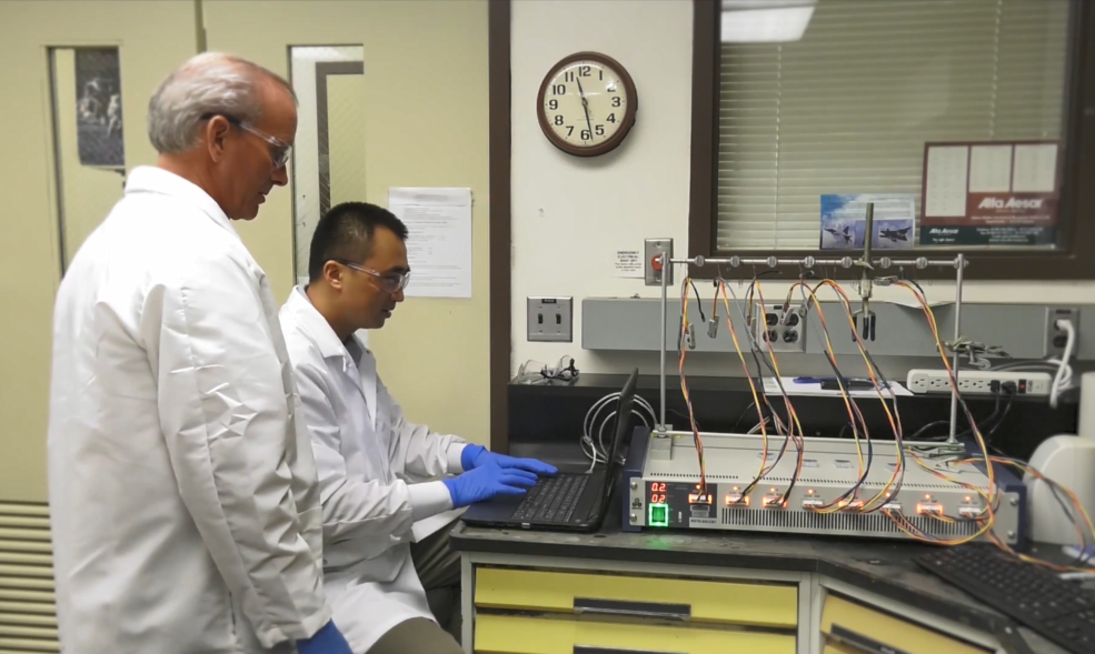 美国宇航局的研究人员John Connell和Yi Lin（坐着）正在使用循环电压表来检查全新阴极的性能水平。
